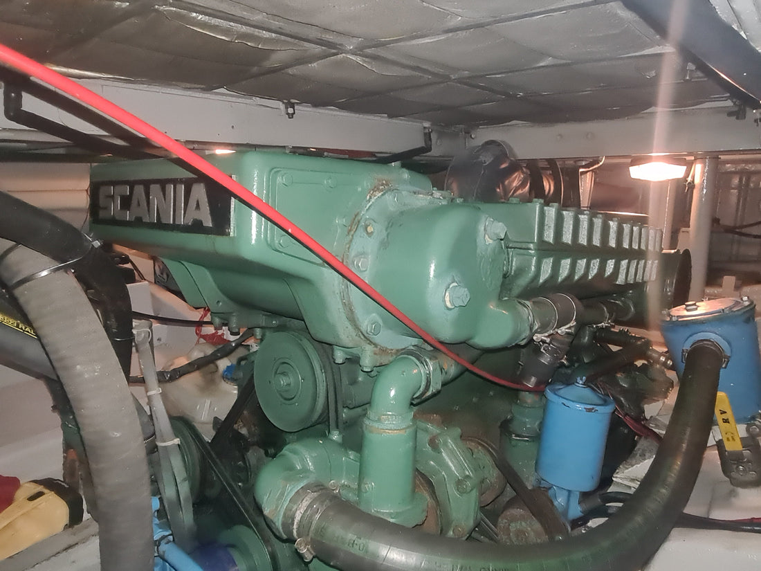 Scania marine diesel in an engine room with its fuel filter and cooling hoses in view