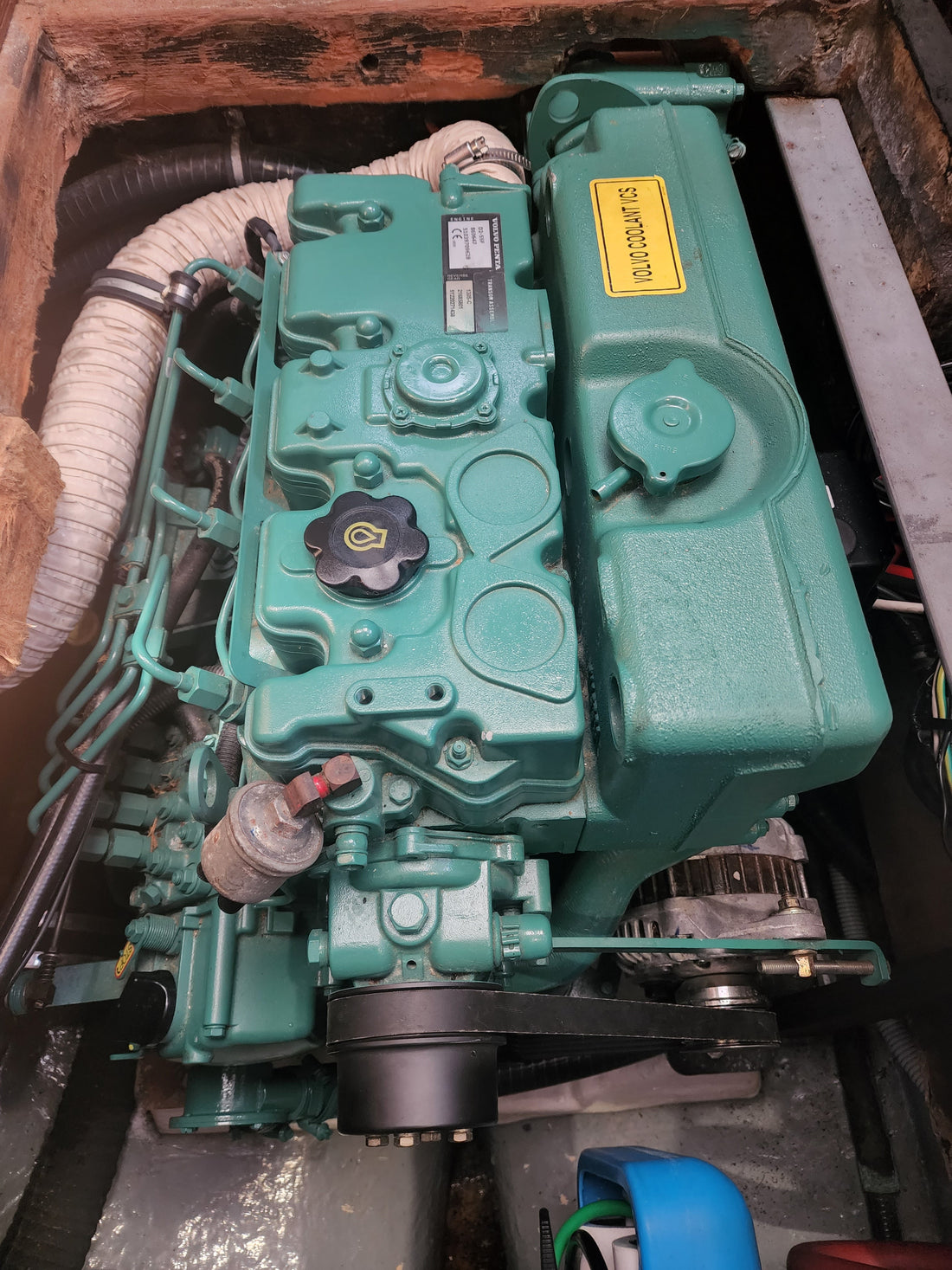 Older Volvo Penta marine diesel in a timber-lined engine bay, identification plate visible