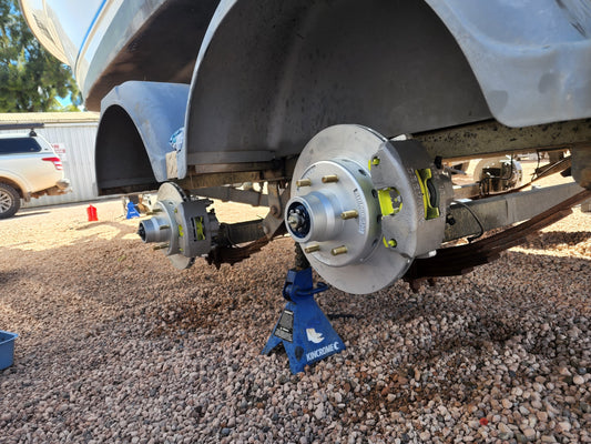 Boat trailer hubs and disc brakes raised on a jack stand for bearing service