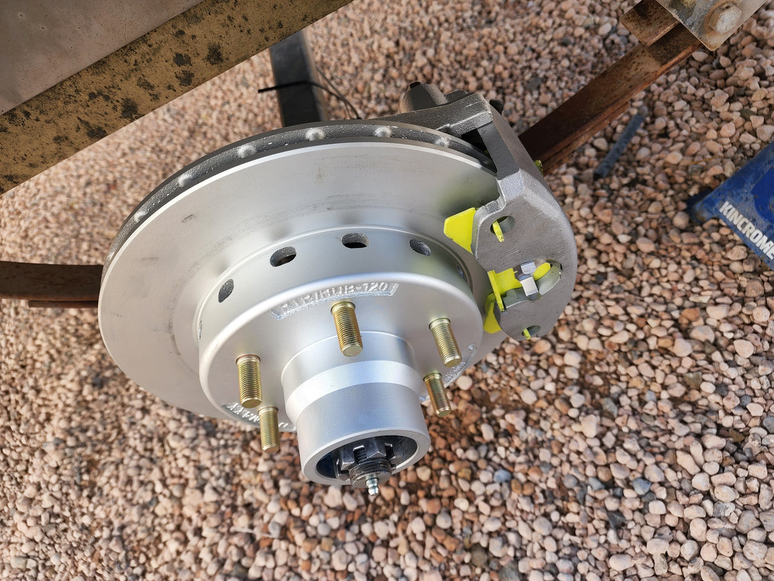 Disc brake rotor, caliper and hub on a boat trailer axle during a brake service